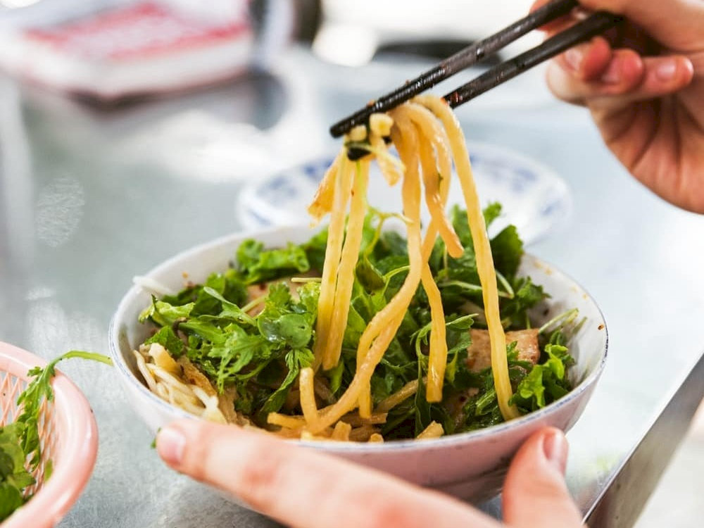 Enjoying a delicious bowl of Cao Lau - thick, chewy noodles